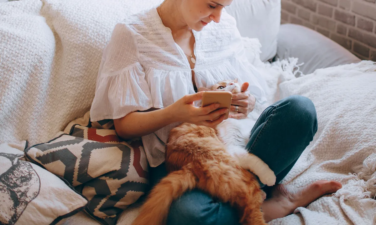 A renter relaxing on a sofa with a cat at home